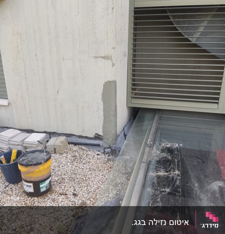 דלי צבע לאיטום ליד קיר עם תיקון טיח